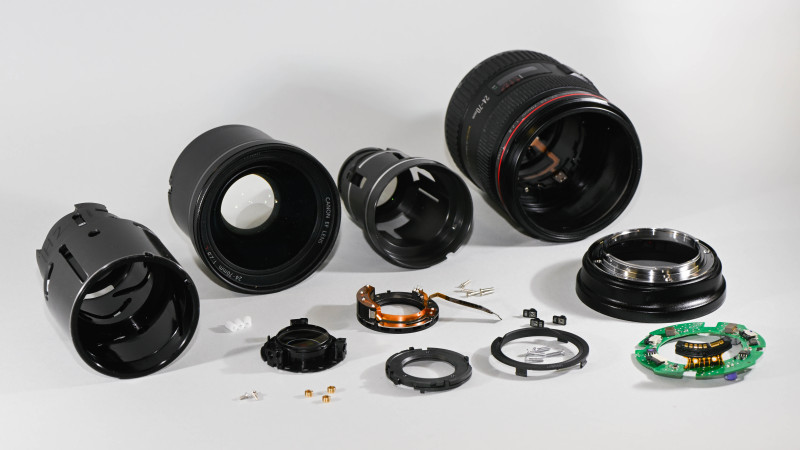 Objectif Canon 24-70mm f/2.8L USM démonté en plusieurs parties : groupes optiques, barillet, bague de monture avec contacts électriques et platine électronique verte
